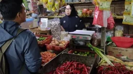 Pedagang sayur-mayur di Pasar Tomang Barat, Grogol Petamburan, Jakarta Barat, Nuh (65) tengah bertransaksi dengan pembeli, Kamis (19/2/2026). (Foto: Tera Nusantara.com)